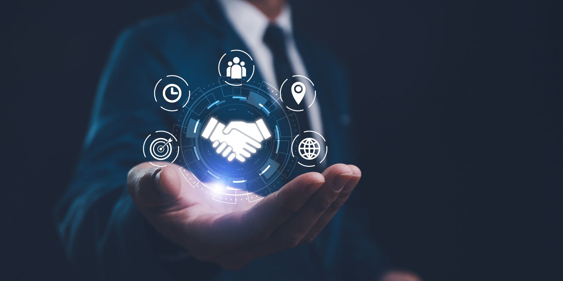 A businessman presents a holographic global partnership concept, with interconnected icons floating above his hand. Business partnerships concept. Business collaboration strategies.